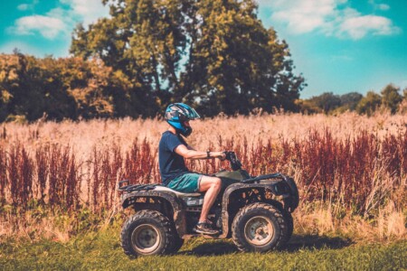 Man on a quad bike at Camp Wildfire. A summer weekend break in a forest near London and Kent. An outdoor woodland retreat featuring adventure activities, live music, DJs, parties and camping. Half summer adventure activity camp, half music festival, for adults only.