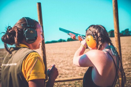 People at the clay shooting activity at Camp Wildfire. A summer weekend break in a forest near London and Kent. An outdoor woodland retreat featuring adventure activities, live music, DJs, parties and camping. Half summer adventure activity camp, half music festival, for adults only.