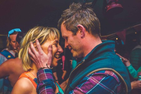 Couple on the dance floor at Camp Wildfire. A summer weekend break in a forest near London and Kent. An outdoor woodland retreat featuring adventure activities, live music, DJs, parties and camping. Half summer adventure activity camp, half music festival, for adults only.