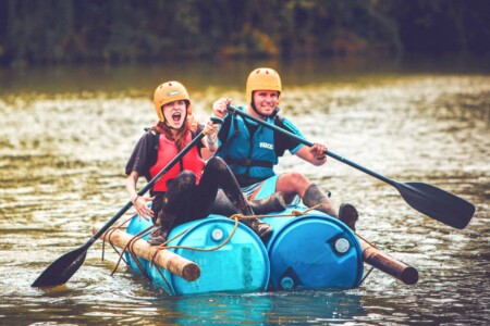 People at the raft building at Camp Wildfire. A summer weekend break in a forest near London and Kent. An outdoor woodland retreat featuring adventure activities, live music, DJs, parties and camping. Half summer adventure activity camp, half music festival, for adults only.