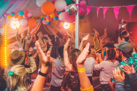 People clapping for Company B Swing at Camp Wildfire. A summer weekend break in a forest near London and Kent. An outdoor woodland retreat featuring adventure activities, live music, DJs, parties and camping. Half summer adventure activity camp, half music festival, for adults only.