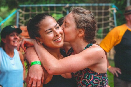 A girl giving a kiss on the cheek to a fellow adventurer at Camp Wildfire. The UK's Best Alternative Festival. UK's Top Unique Event. A summer weekend break in a forest near London and Kent. An outdoor woodland retreat featuring adventure activities, live music, DJs, parties and camping. Half summer adventure activity camp, half music festival, for adults only.