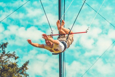 Man in the air on the flying trapeze at Camp Wildfire