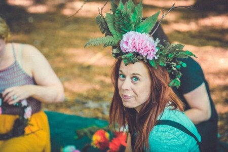 Girl with homemade natural headpiece on at Camp Wildfire. A summer weekend break in a forest near London and Kent. An outdoor woodland retreat featuring adventure activities, live music, DJs, parties and camping. Half summer adventure activity camp, half music festival, for adults only.